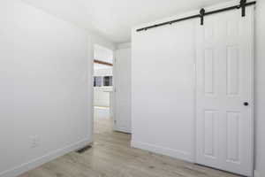 Interior space with a barn door and light hardwood / wood-style flooring