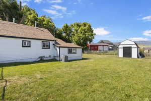 View of yard with a storage shed and central AC