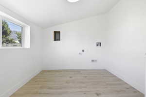 Washroom featuring electric dryer hookup, hookup for a washing machine, and light wood-type flooring