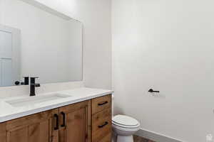 Bathroom featuring hardwood / wood-style floors, vanity, and toilet