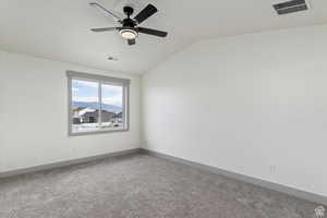 Empty room with carpet flooring, ceiling fan, and lofted ceiling