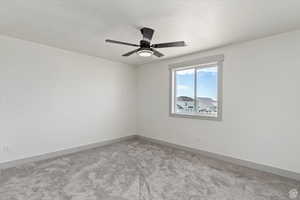 Unfurnished room with light carpet and a textured ceiling