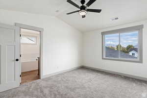 Unfurnished bedroom featuring carpet, ceiling fan, and vaulted ceiling