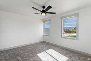 Empty room featuring carpet flooring and ceiling fan