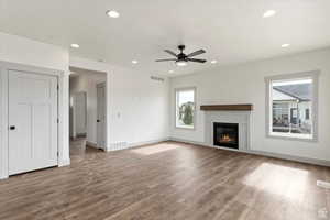 Unfurnished living room featuring hardwood / wood-style floors, a textured ceiling, and ceiling fan