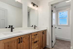 Bathroom featuring hardwood / wood-style floors, vanity, and toilet