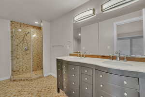 Bathroom featuring vanity, a textured ceiling, and walk in shower