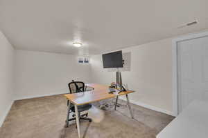 Carpeted home office with a textured ceiling