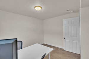 Office area with carpet floors and a textured ceiling