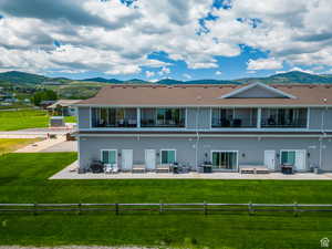 Rear view of property with a mountain view, a patio, and a balcony