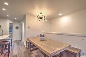 Dining space featuring sink, dark hardwood / wood-style flooring, and a notable chandelier