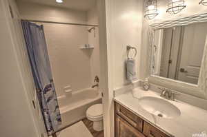 Full bathroom featuring shower / bath combo, vanity, toilet, and wood-type flooring