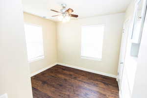 Empty room with dark hardwood / wood-style flooring and ceiling fan