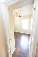 Hallway with dark hardwood / wood-style flooring and a textured ceiling