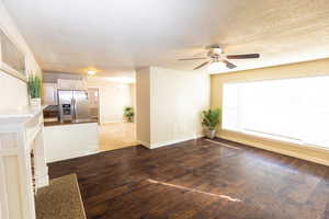 Spare room with ceiling fan, dark hardwood / wood-style flooring, and a textured ceiling