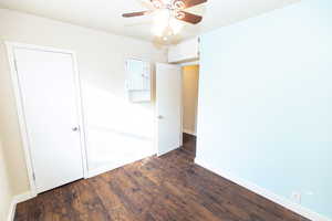 Spare room with ceiling fan and dark wood-type flooring