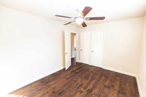 Unfurnished bedroom featuring ceiling fan and dark wood-type flooring