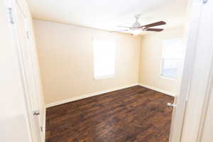 Spare room with ceiling fan and dark hardwood / wood-style flooring