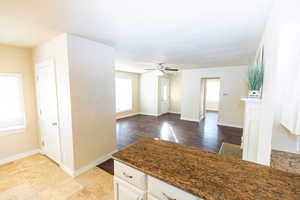 Kitchen featuring dark stone counters, white cabinets, ceiling fan, a textured ceiling, and light hardwood / wood-style floors