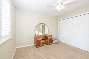 Second Bedroom with ceiling fan, a closet, and carpet floors