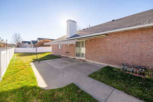 Rear view of house featuring a lawn and a covered patio area