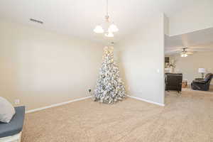 Interior space with ceiling fan with notable chandelier and lofted ceiling