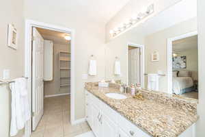 Primary Bathroom featuring tile patterned floors and vanity, Walk-in closet