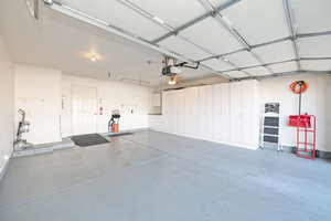 Garage with a garage door opener, work bench and storage cabinets