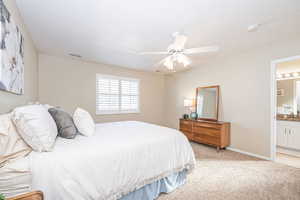 Carpeted Primary bedroom with ensuite bathroom and ceiling fan, plantation shutters