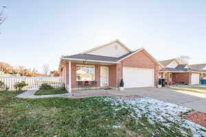 Patio Home featuring a porch, a garage, and a front yard