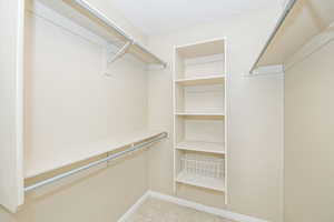 Primary walk in closet with light tile patterned floors