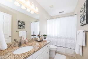 Guest Bathroom with tile patterned flooring, vanity, and toilet