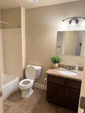 Full bathroom featuring tile patterned flooring, vanity, toilet, and shower / tub combination