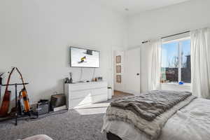 Bedroom with carpet and a towering ceiling