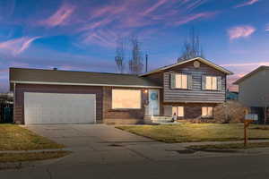 Split level home featuring a yard and a garage