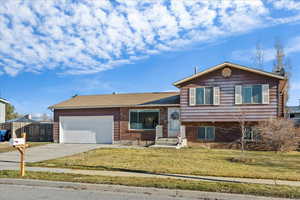 Tri-level home with a garage and a front lawn