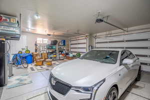 Garage featuring stainless steel fridge and a garage door opener