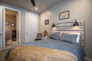 Bedroom featuring ceiling fan, Full bathroom, a closet, and light colored carpet