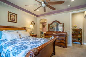 Carpeted bedroom featuring ceiling fan