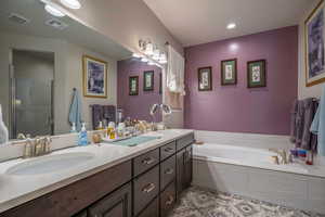 Primary Owner Bathroom featuring plus walk in shower and vanity