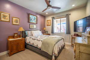 Guest bedroom #2 featuring ceiling fan and a textured ceiling