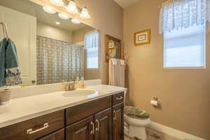 Guest Bathroom #2  featuring vanity, toilet, and a healthy amount of sunlight