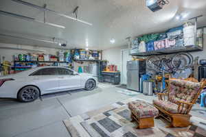 Garage featuring a garage door opener and EPOXY FLOORING 2023