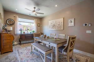 Dining space featuring ceiling fan, light hardwood / wood-style floors, and a textured ceiling