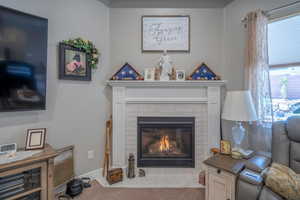 Carpeted living room featuring a fireplace