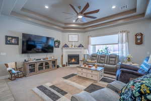 Living room with ceiling fan and a raised ceiling