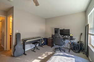 Carpeted office space featuring ceiling fan