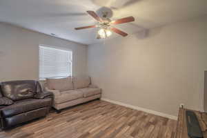 Living room with ceiling fan and hardwood / wood-style floors