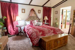 Carpeted bedroom with a textured ceiling, crown molding, and lofted ceiling