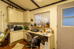 Home office featuring built in desk, dark hardwood / wood-style floors, and a textured ceiling